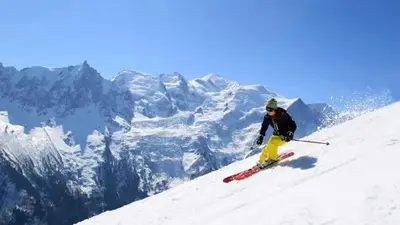 a man is skiing down a snow covered mountain at Apartment Planards Centre Chamonix foot of the Planards Slopes in Chamonix-Mont-Blanc