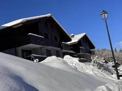 a pile of snow next to a building with a street light at Appartement 3 pièces cosy, 6 personnes, près de la piscine et du ski bus, parking inclus. - FR-1-572-285 in Arâches-la-Frasse