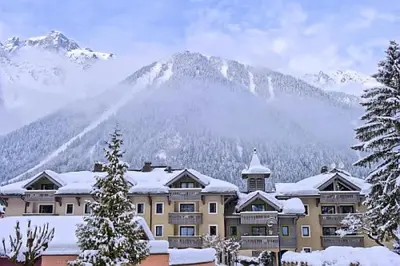 a large building with a mountain in the background at Résidence La Ginabelle - maeva Home - 2 Pièces 4 Personnes Prestige MAE-1307 in Chamonix-Mont-Blanc