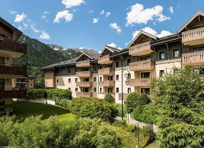 a group of apartment buildings with a grassy yard at Résidence La Ginabelle - maeva Home - Appartement 2 Pièces 4 Personnes - Sélection MAE-9584 in Chamonix-Mont-Blanc