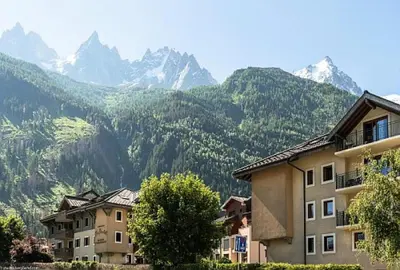 a group of buildings with mountains in the background at Résidence La Ginabelle - maeva Home - Appartement 3 pièces 6 personnes - Prestige MAE-3904 in Chamonix-Mont-Blanc