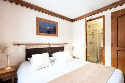 a bedroom with a white bed and a shower at Résidence La Ginabelle - maeva Home - Appartement 3 pièces 6 personnes - Prestige MAE-4054 in Chamonix-Mont-Blanc