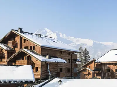 a group of wooden buildings with snow covered roofs at Résidence Les Fermes du Soleil - maeva Home - Appartement 3 pièces 5 personnes - Sélection MAE-9504 in Les Carroz d'Araches