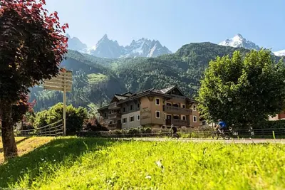 a person riding a bike in front of a house at Résidence La Ginabelle - maeva Home - Appartement 3 pièces 6 personnes - Prestige MAE-4044 in Chamonix-Mont-Blanc