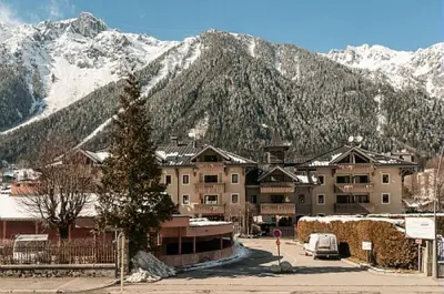 a large building in front of a snow covered mountain at Résidence La Ginabelle - maeva Home - Appartement 3 pièces 6 personnes - Prestige MAE-4044 in Chamonix-Mont-Blanc