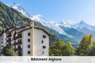 a building in front of a mountain with snow at L'Aiguille - maeva Home - 2 Pièces 5 Personnes Confort MAE-1176 in Chamonix-Mont-Blanc
