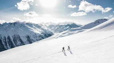 two people skiing down a snow covered mountain at Amethyste - 2 Bedrooms & Free Parking - By Cozee Rentals in Les Houches