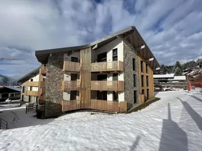 a apartment building in the snow with snow at Superbe appart 3P au pied des pistes, parking couvert, terrasse, WiFi - Les Carroz - FR-1-572-288 in Arâches-la-Frasse