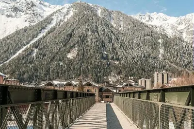 a bridge over a city with a mountain in the background at Résidence La Ginabelle - maeva Home - Appartement 4 Pièces 8 Personnes - Sélection MAE-7444 in Chamonix-Mont-Blanc