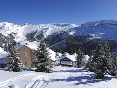 a house in the snow with trees and mountains at Chalet lumineux à Flaine avec garage et grand salon - FR-1-425-210 in Arâches-la-Frasse