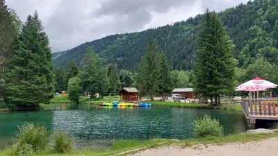 a lake with a house and a group of rafts at Studio au pied des remontées/wifi/smart TV/parking in Les Contamines-Montjoie