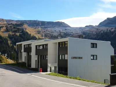 an office building with a mountain in the background at Appartement rénové au pied des pistes avec balcon - FR-1-425-215 in Arâches-la-Frasse