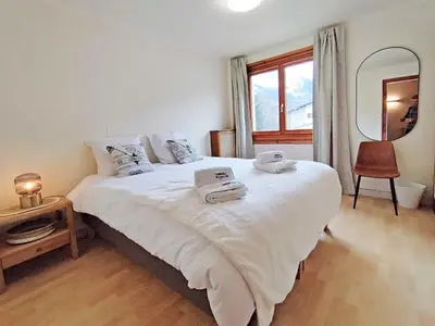 a bedroom with a bed and a desk and a chair at Edelweiss 2 Apartment in Chamonix-Mont-Blanc