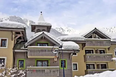 a large building with snow on top of it at Résidence La Ginabelle - maeva Home - Appartement 4 Pièces 8 Personnes - Sélection MAE-1965 in Chamonix-Mont-Blanc