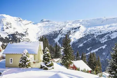 a house in the snow with mountains in the background at Les Chalets de Flaine Hameau - maeva Home - Chalet 4 Pièces 8 Personnes - Sélection MAE-3386 in Flaine