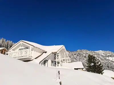 a person skiing down a snow covered slope in front of a house at Les Chalets de Flaine Hameau - maeva Home - Chalet 3 Pièces 8 Personnes - Confort MAE-3392 in Flaine