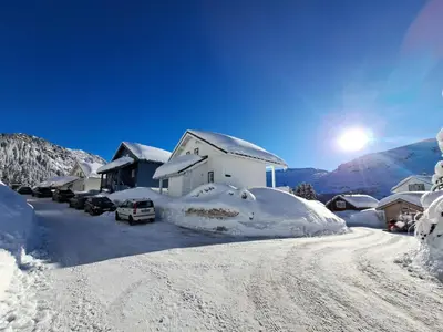 a snow covered street with a house and cars parked at Les Chalets de Flaine Hameau - maeva Home - Chalet 3 Pièces 8 Personnes - Confort MAE-3392 in Flaine