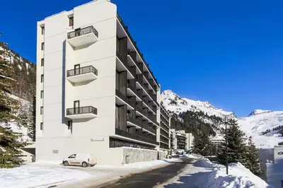 a white building with a car parked in front of it at Résidence Andromède - maeva Home - Studio 4 Personnes - Budget MAE-3652 in Flaine
