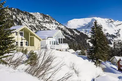 a house in the snow with mountains in the background at Les Chalets de Flaine Hameau - maeva Home - Chalet 4 Pièces 8 Personnes - Confort MAE-3662 in Flaine