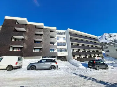 two cars parked in a parking lot in front of a building at Résidence Pégase - maeva Home - Studio 4 Personnes - Budget MAE-3664 in Flaine