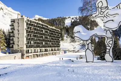 a building in the snow in front of a mountain at Résidence Aldébaran - maeva Home - Appartement 2 Pièces 6 Personnes - Prestige MAE-3791 in Arâches-la-Frasse
