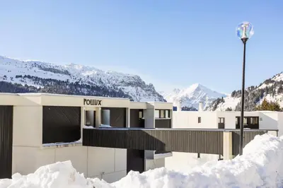a building in the snow with mountains in the background at Résidence Pollux - maeva Home - Appartement 2 pièces 6 personnes - Budget MAE-4210 in Arâches-la-Frasse
