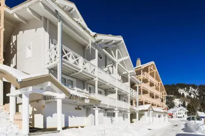a large white building with snow on the ground at Résidence Le Château de Crans - maeva Home - Appartement 5 pièces 10 personnes avec sauna privé - Prestige MAE-4441 in Flaine