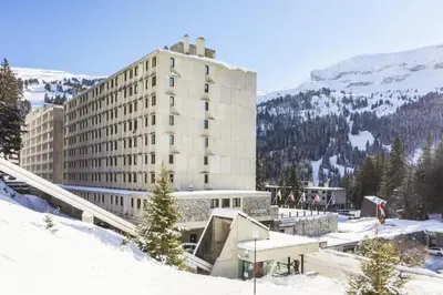 a building in the snow in front of a mountain at Résidence Cassiopée - maeva Home - Appartement 4 pièces 6 personnes - Confort MAE-3654 in Arâches-la-Frasse