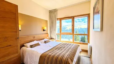 a bedroom with a bed and a large window at Résidence Les Terrasses D'eos - Appartement spacieux · Accès direct aux pistes · Piscine · WIFI gratuit et illimité · Spa MAE-1661 in Magland