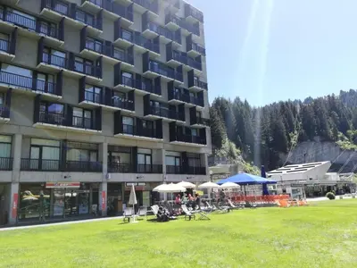 a large building with chairs and umbrellas in the grass at Résidence Aldébaran - maeva Home - Appartement 2 Pièces 6 Personnes - Confort MAE-3790 in Arâches-la-Frasse