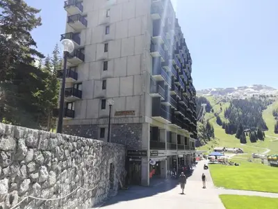 a building on a hill with people walking in front of it at Résidence Aldébaran - maeva Home - Appartement 2 Pièces 6 Personnes - Confort MAE-3790 in Arâches-la-Frasse