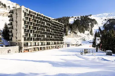 a large building in the snow in front of a mountain at Résidence Aldébaran - maeva Home - Appartement 2 Pièces 6 Personnes - Confort MAE-3790 in Arâches-la-Frasse