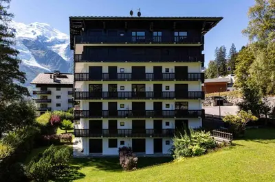 a building with balconies and a mountain in the background at Le Brevent 2 Apartment - Chamonix All Year in Chamonix-Mont-Blanc