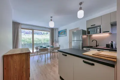 a kitchen with a counter and a dining room at Alpina 108 départ ski & rando depuis le Bettex in Saint-Gervais-les-Bains