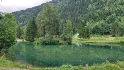 a lake in the middle of a field with trees at Studio cosy au pied des remontées,wifi,smart TV,parking in Les Contamines-Montjoie