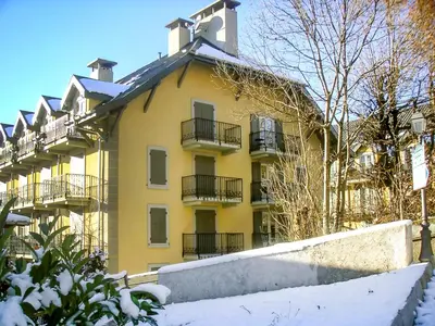 a chair sitting on a wooden deck next to a house at Apartment Conseil-9 by Interhome in Saint-Gervais-les-Bains