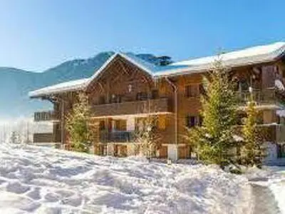 a large wooden house in the snow with mountains at Chalet avec terrasse et animaux acceptés, proche centre et ski-bus - FR-1-624-169 in Samoëns