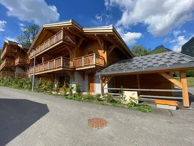 a large wooden house with a gambrel roof at Appartement lumineux avec parking à Samoëns, animaux admis - FR-1-624-170 in Samoëns