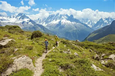 two people walking on a trail in the mountains at Delice - City center Les Houches & Free Parking - By Cozee Rentals in Les Houches