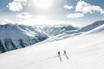 two people skiing down a snow covered mountain at Le Freney - New Apartment in Town Center & Free parking - By Cozee Rentals in Les Houches