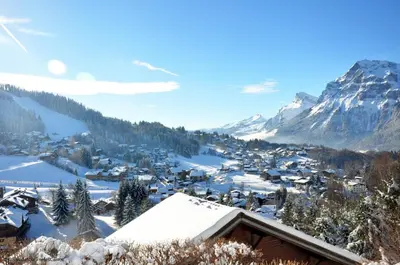a village covered in snow with a mountain in the background at ob219 4 pieces duplex 6 personnes proche pistes in Les Carroz d'Araches