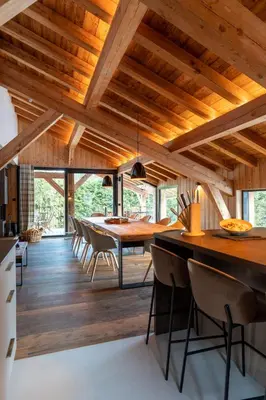 a dining room with wooden ceilings and a table and chairs at Chalet de 8 chambres MEGEVE - 16 personnes in Megève