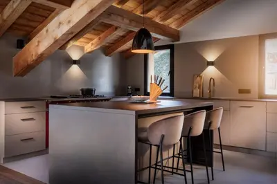 a kitchen with a large island with bar stools at Chalet de 8 chambres MEGEVE - 16 personnes in Megève