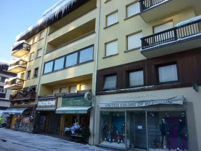 a tall yellow building with shops on a street at Appartement Pratique Centre Megève - 4 Pers - Animaux Bienvenus - FR-1-453-324 in Megève