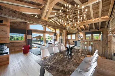 a dining room with a table and white chairs at Chalet Le Chardon Bleu in Megève