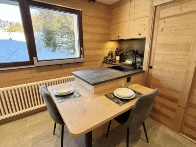 a wooden kitchen with a wooden table and chairs at Studio confortable proche du centre avec parking, navette et randonnées à Megève - FR-1-597-190 in Megève