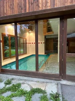 a swimming pool in a house with windows at Samoëns 2 in Samoëns