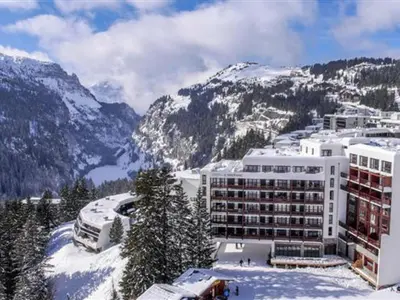 a large building in the snow with mountains at Spacieux appartement avec parking et accès piscine à Flaine - FR-1-425-231 in Arâches-la-Frasse