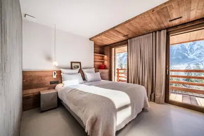 a bedroom with a large bed with white pillows at Chalet Foxden in Les Houches