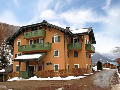 a large building with balconies and snow on the ground at Duplex vue sur montagne in Saint-Gervais-les-Bains